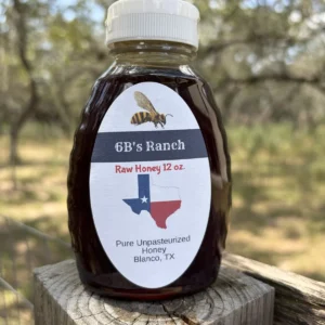6B's Ranch 12 oz Blanco raw honey, dark amber, on a fence post