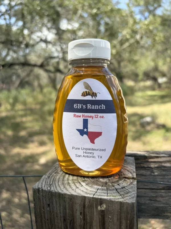 6B's Ranch 12 oz San Antonio raw honey, light golden, on a fence post